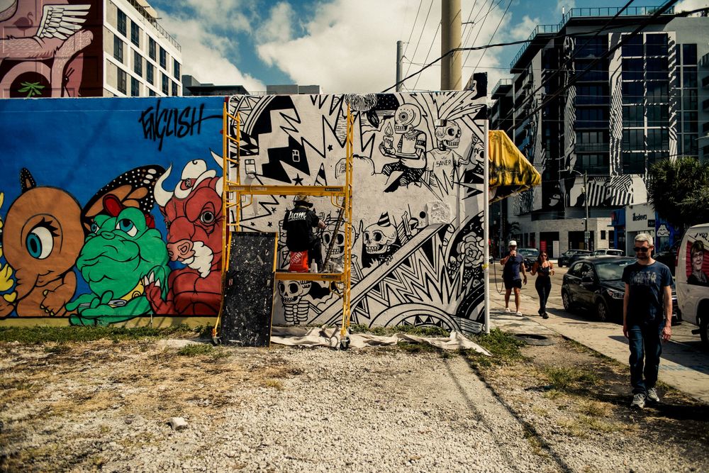 Vibrant street art mural featuring colorful cartoon characters and graffiti on urban wall.
