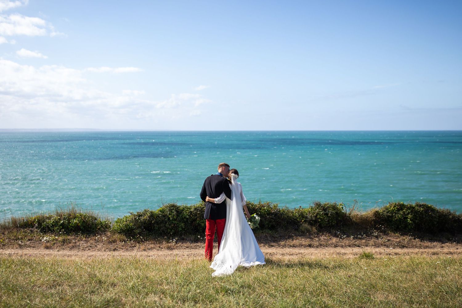 couple qui regarde la mer en s'embrassant photographie de mariage