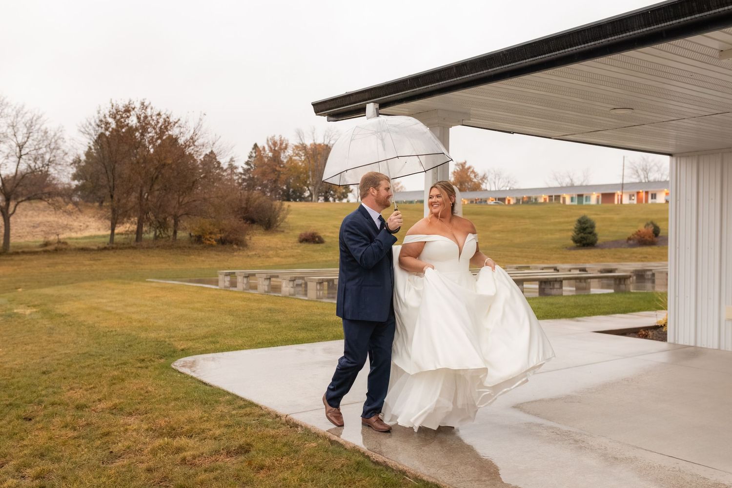 Romantic first dance sequence under warm string lights in a rustic barn venue.