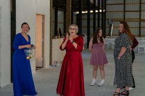 A group in colorful dresses socializing in an indoor venue space.