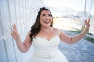 Candid bridal portraits showing joyful expressions against white curtained backdrop.