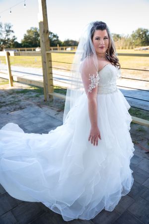 Artistic bridal portraits showcasing the movement and layers of a white wedding gown outdoors.