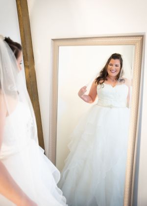 White wedding dress details shown in series of close-up shots highlighting the flowing tulle and fabric texture.