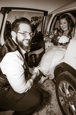 Black and white photos show wedding party getting into vintage car with laughter and joy.
