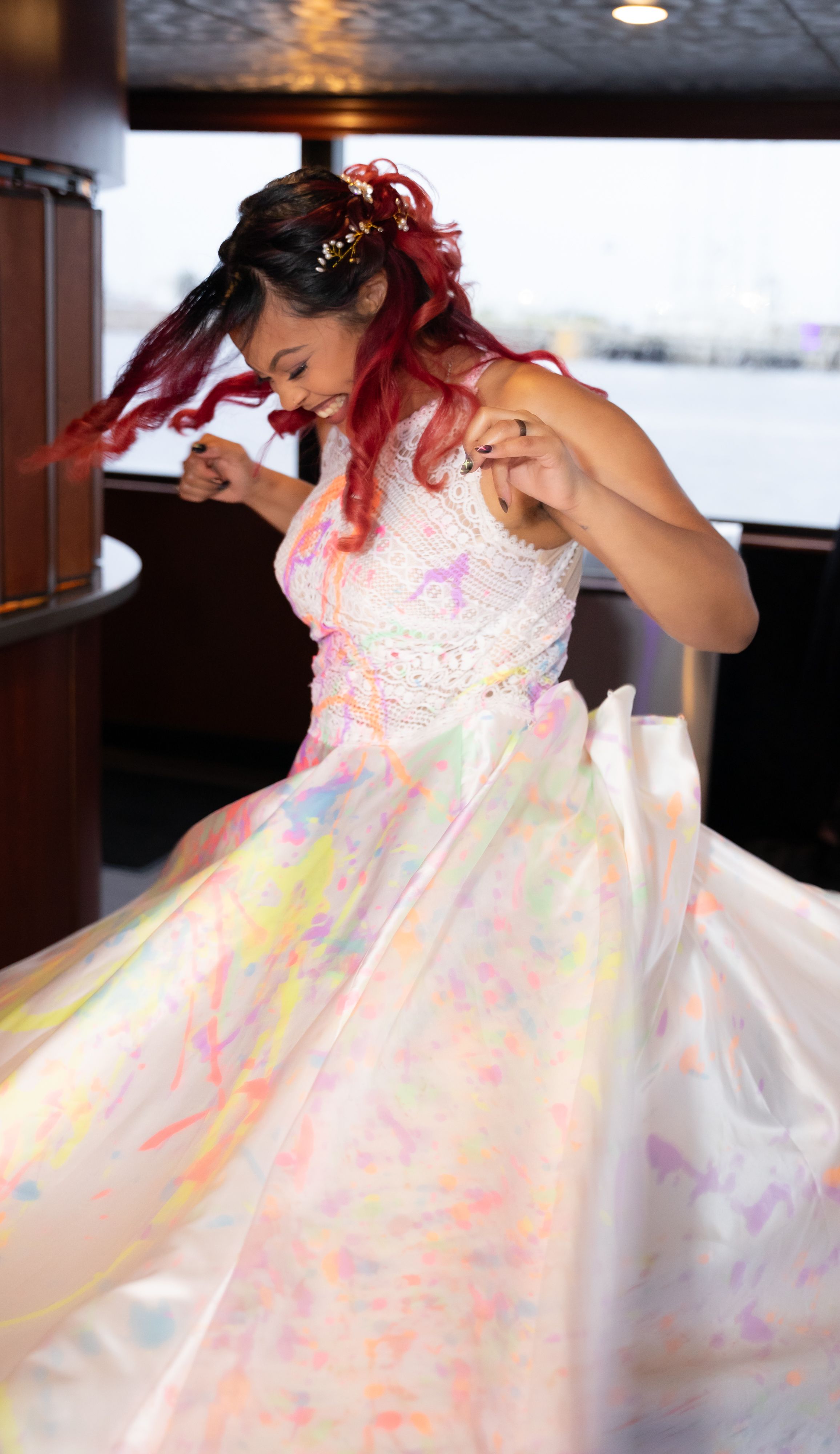 A flowing iridescent wedding dress sparkles with rainbow reflections in natural light.
