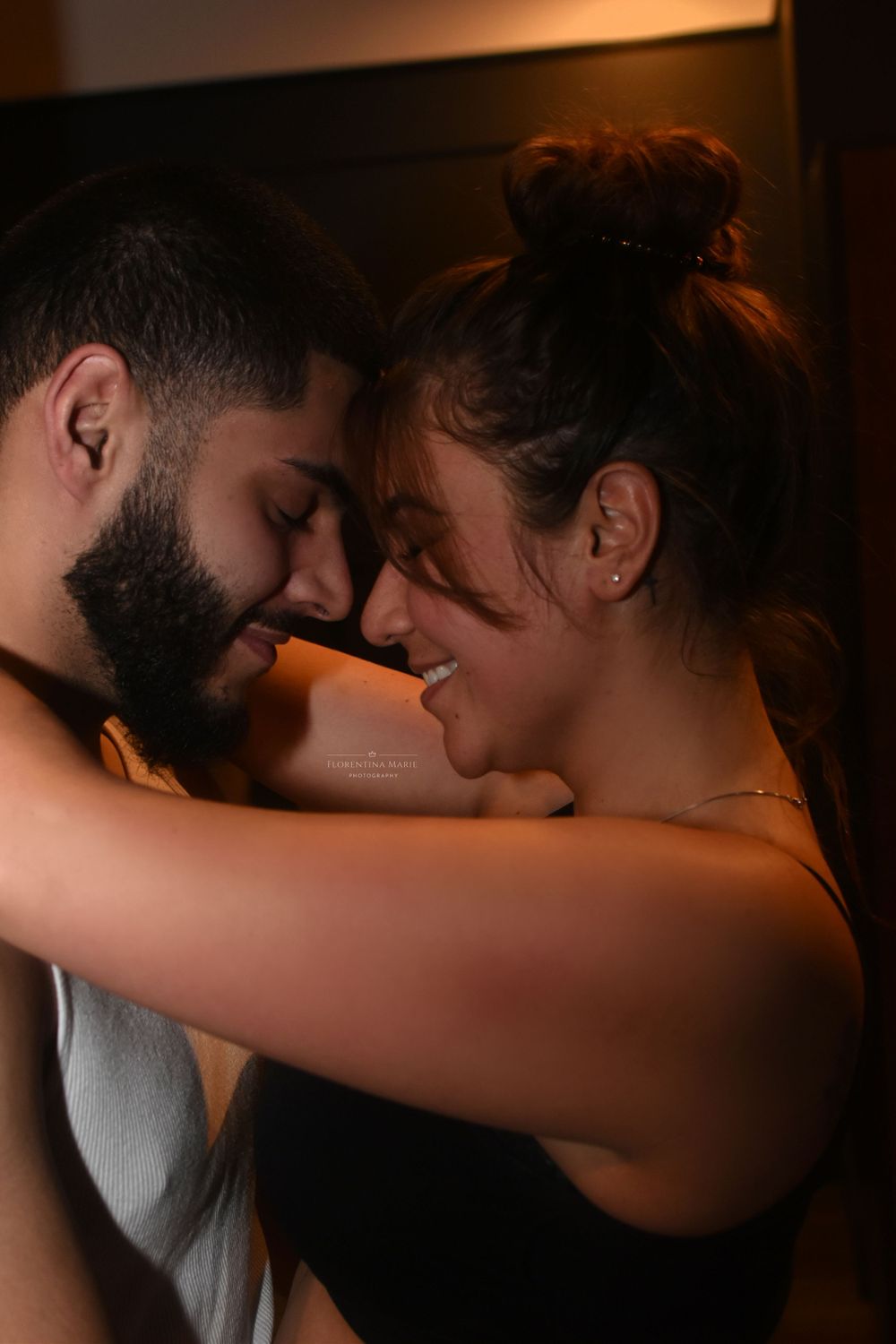 A loving close-up moment between two people with warm ambient lighting.