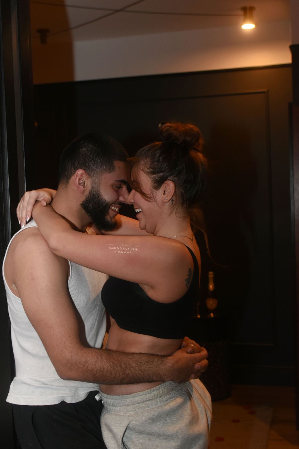 An intimate portrait of two people embracing in warm, dramatic lighting.