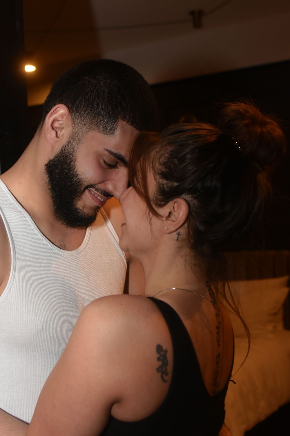 Happy couple sharing a tender moment while embracing in casual attire.