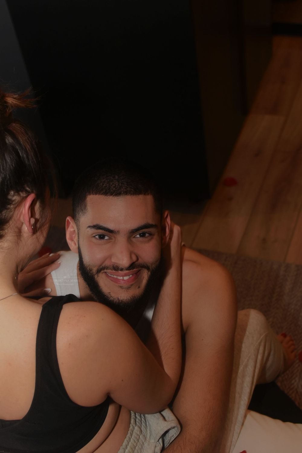Playful intimate moment between couple on bed.