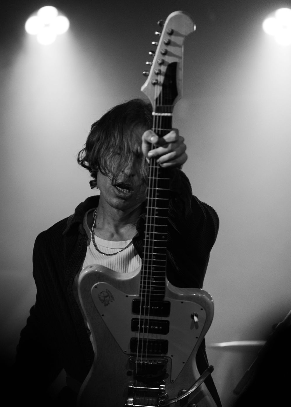 Black and white moody portraits of a guitarist performing with an electric guitar in dramatic lighting.