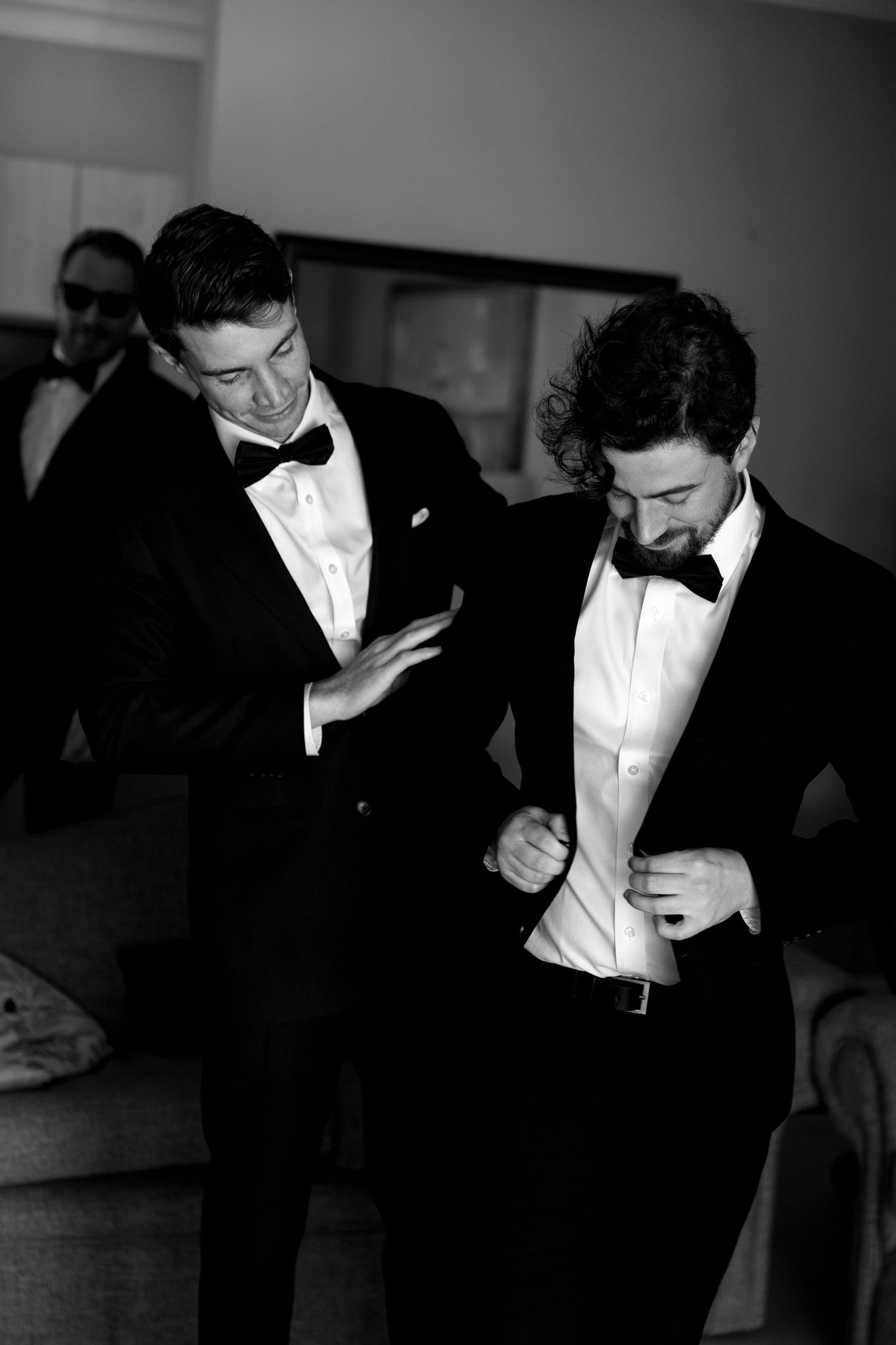 A black and white photo series showing a man in a tuxedo and bowtie adjusting his formal attire.