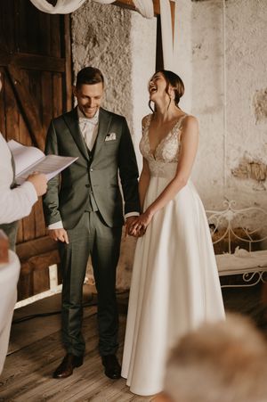 Wedding couple in elegant attire sharing intimate moments in a rustic indoor setting.