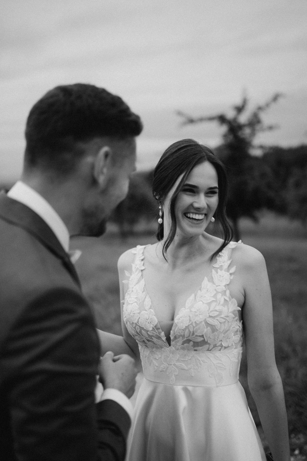 A romantic black and white wedding photo series showing intimate moments between a couple in a lace dress and suit.
