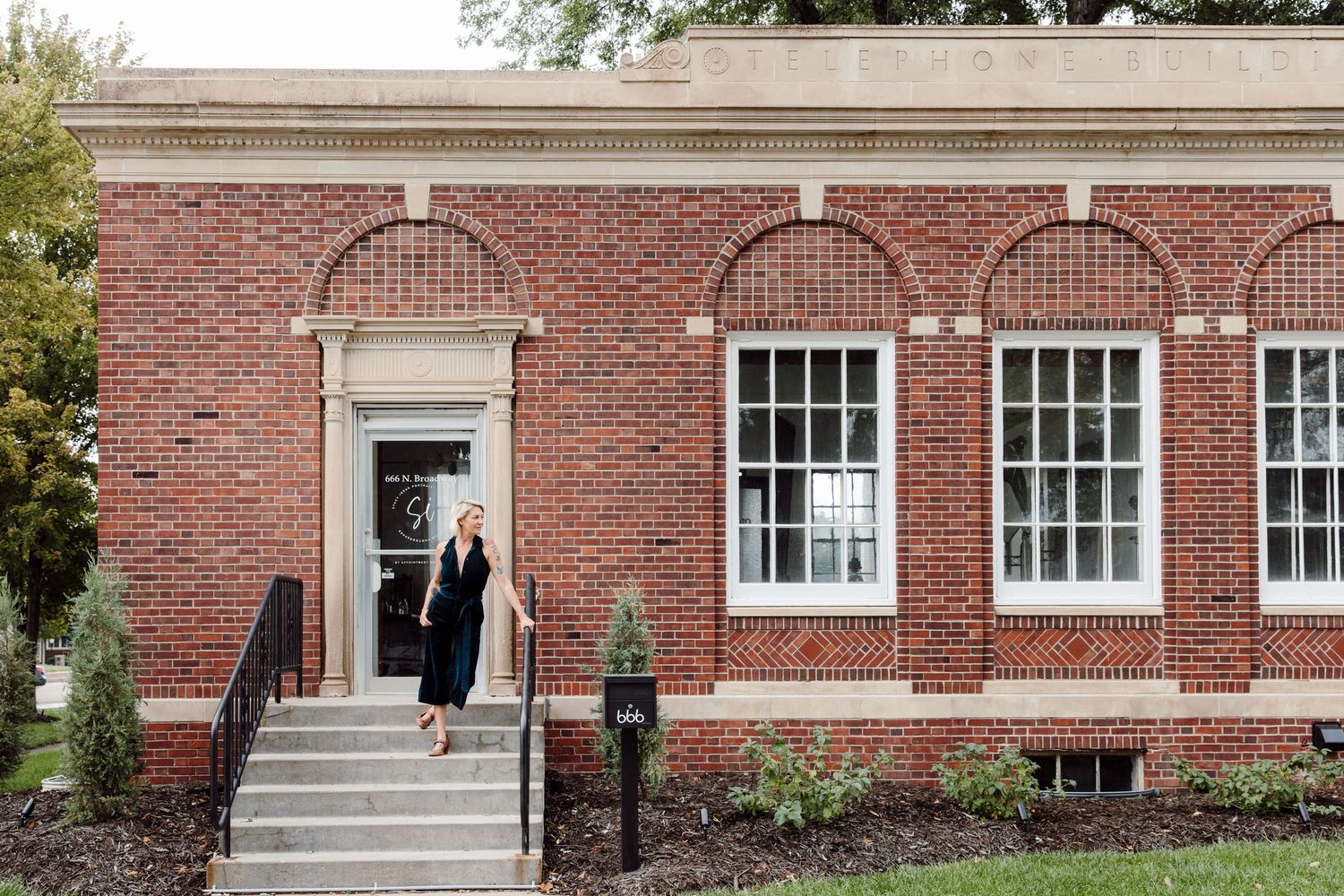 Exterior view of a traditional red brick building with white trim and multiple windows.