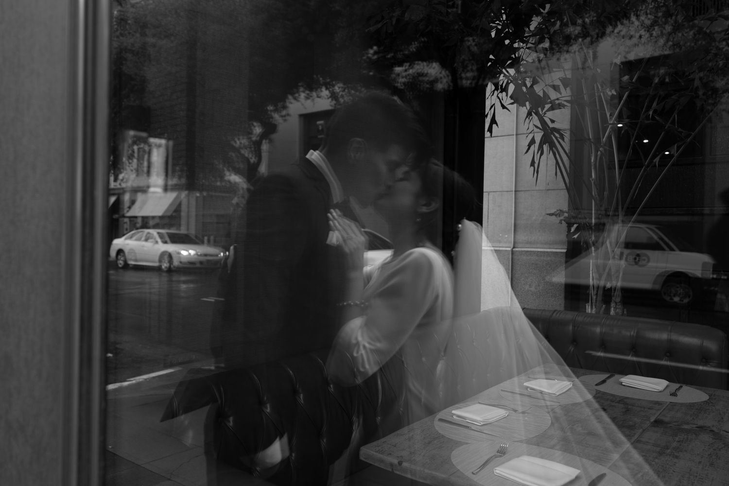 A black and white film noir style image of a newly wed couple kissing for Sacramento wedding celebration