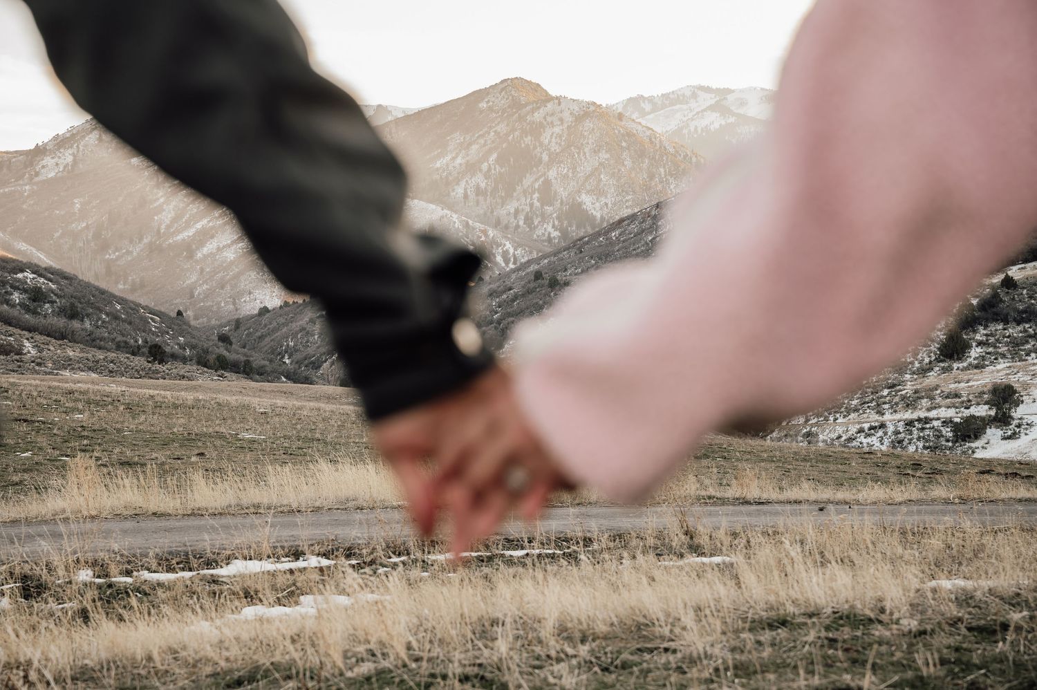 Blurred motion hands reaching across mountain landscape view.