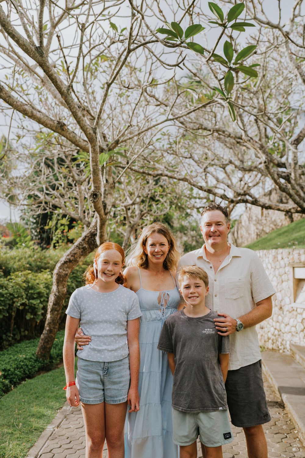 A casual outdoor family photo session showing a group of people posing together against a natural backdrop.
