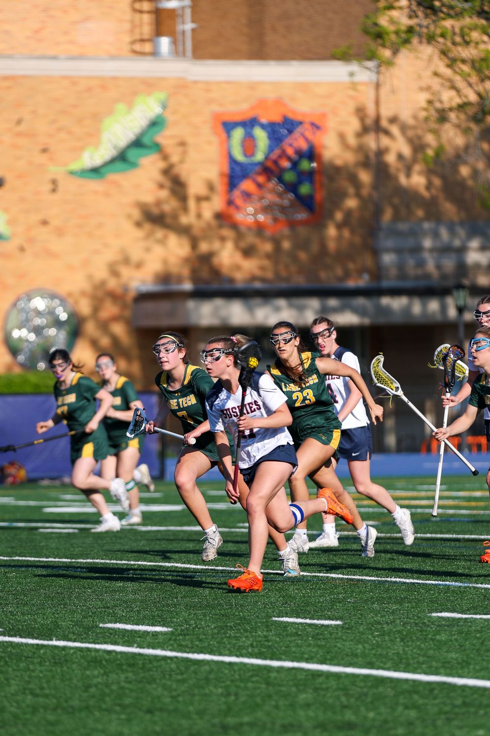Lacrosse players in formation doing ground exercises during practice session.