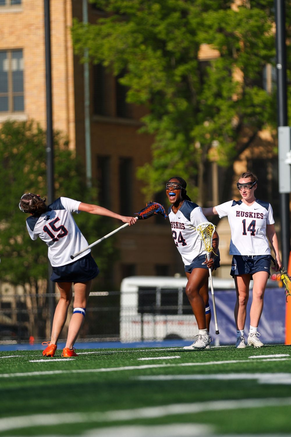 Women's lacrosse team stretches on a sunny field before a game.