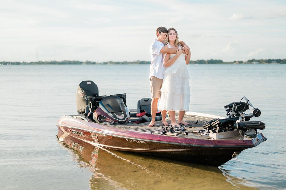 People enjoying a sunny day on a wooden boat with an outboard motor on calm waters.