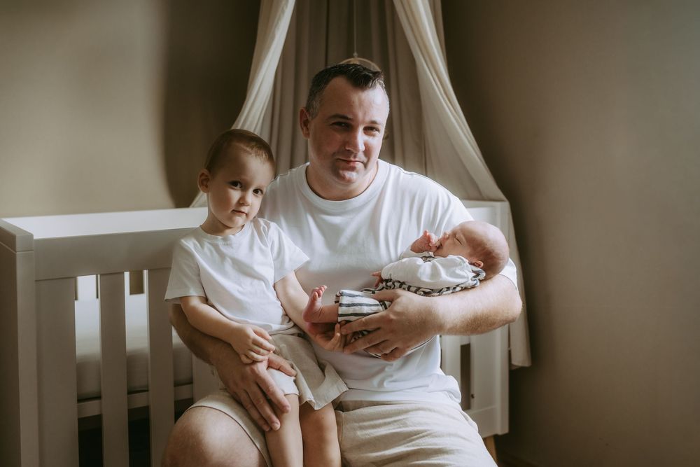 Tender family moment captured in nursery with white decor.