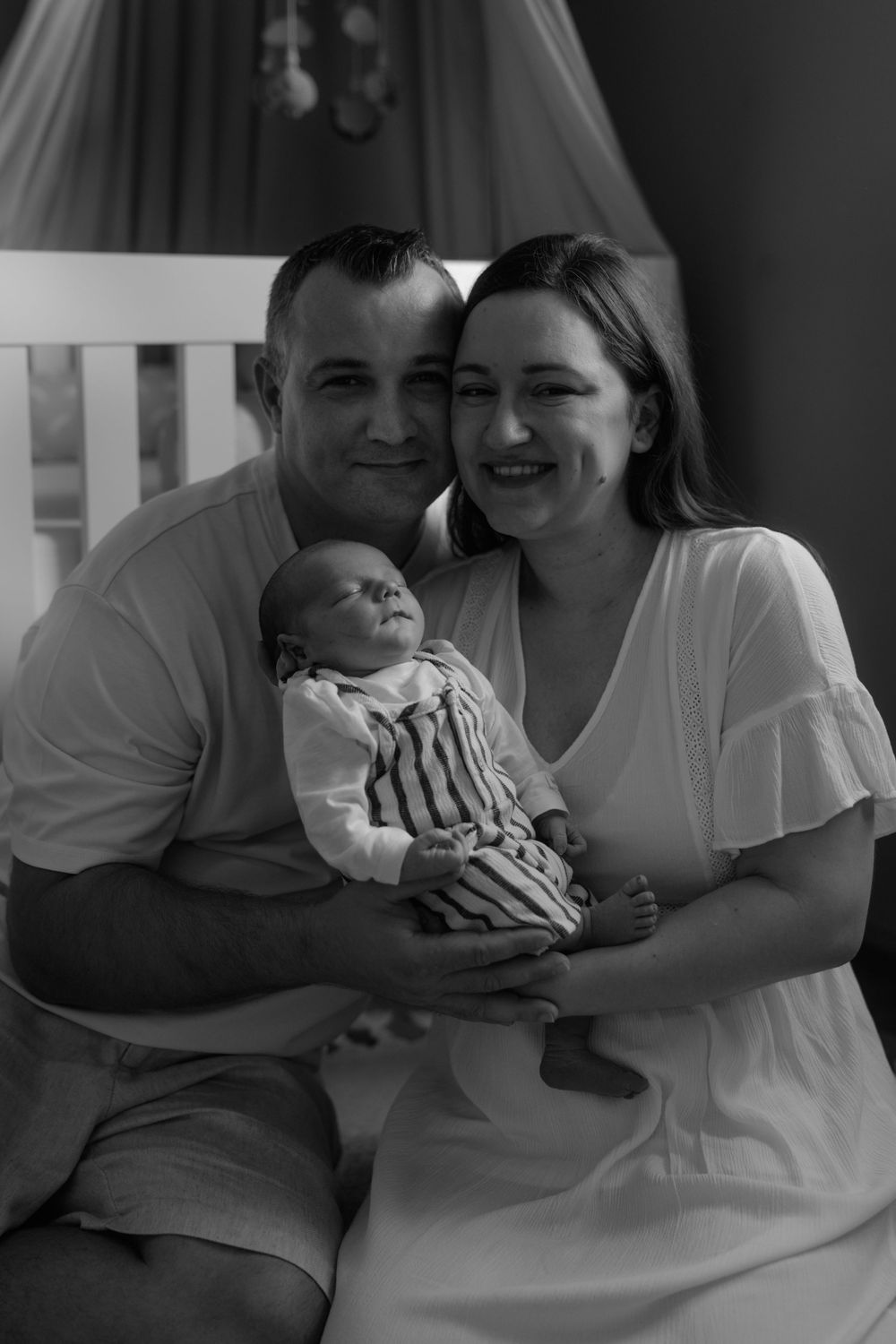 Black and white portrait of family bonding moments in soft lighting.