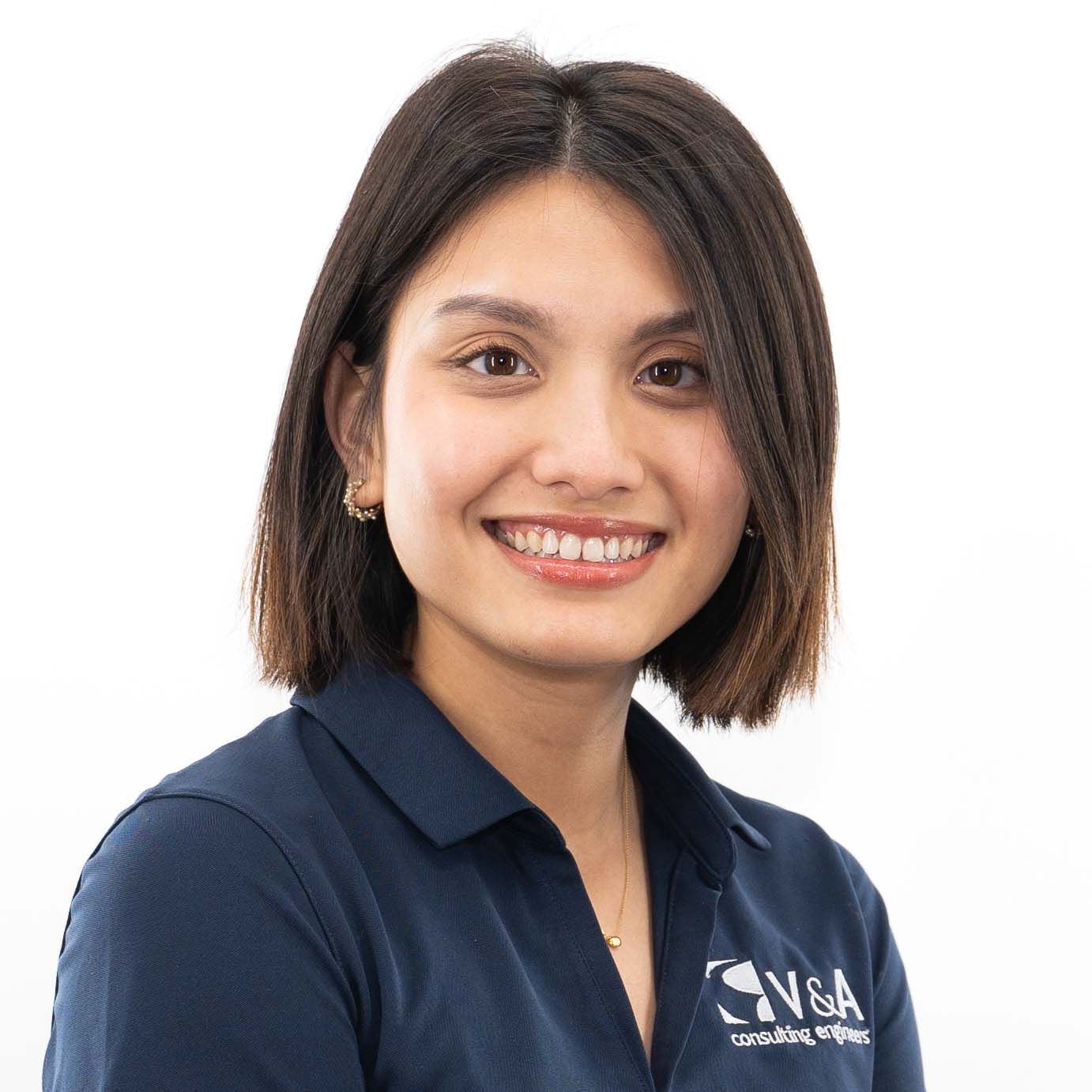 Business professional in a navy blue polo shirt posing for a corporate headshot.