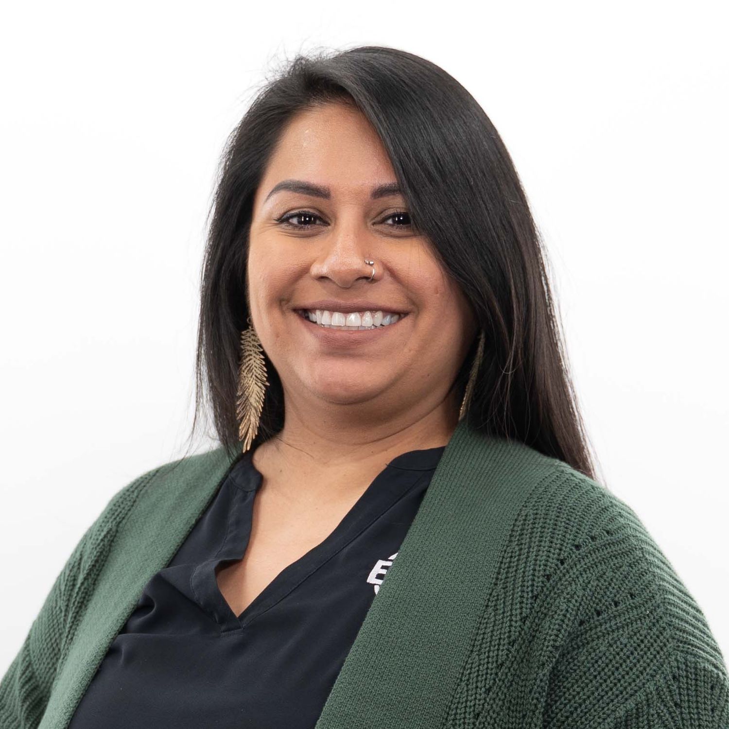 Professional headshot of a woman in a green cardigan smiling warmly against a white background.