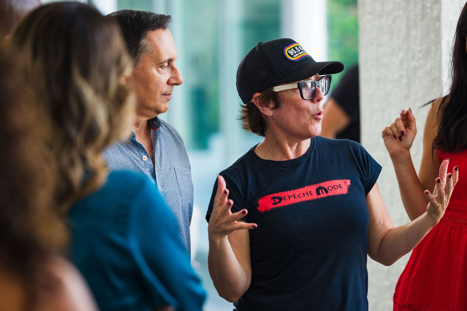A woman holds out her hands, mid-speech, as she directs her film, talking to the cast and crew.