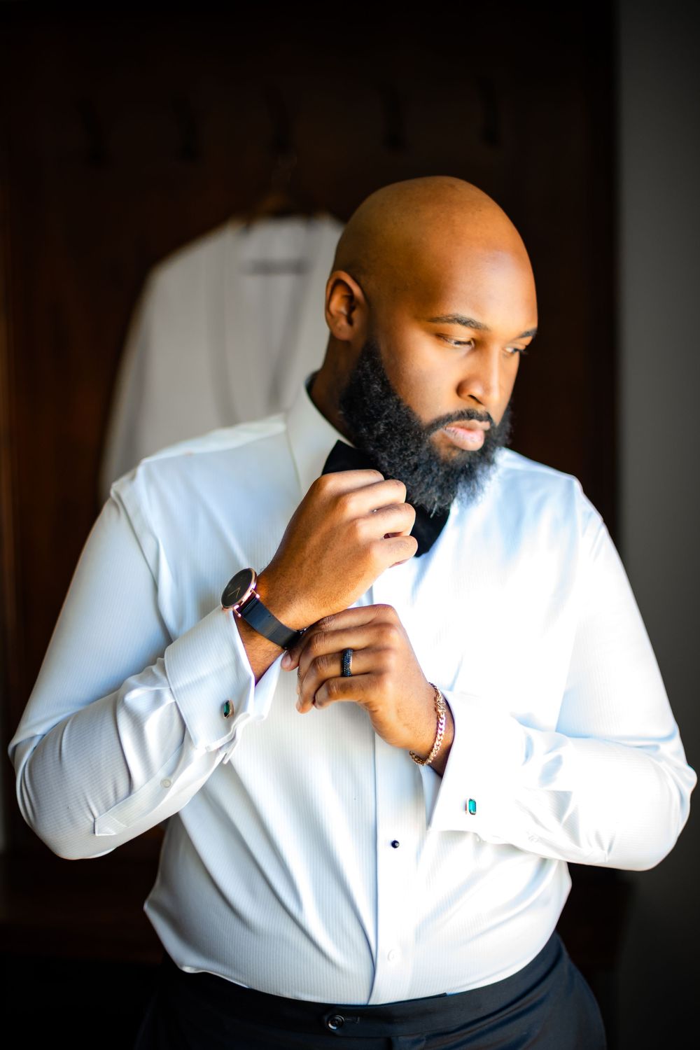A person in a white dress shirt demonstrates a sequence of coughing or sneezing into their elbow.