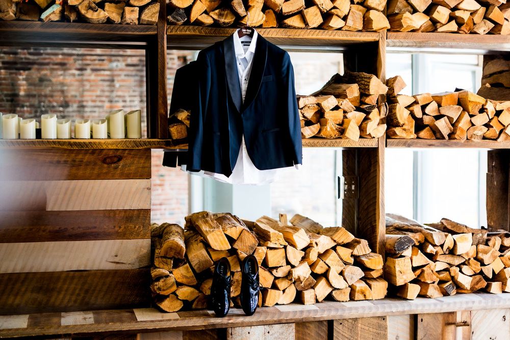 Stacked firewood lines rustic brick wall at wedding venue.