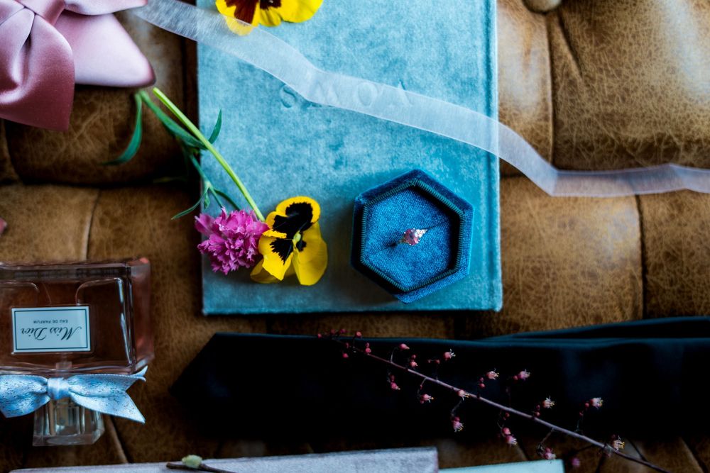 Wedding decor details with blue napkins and yellow flowers on table setting.