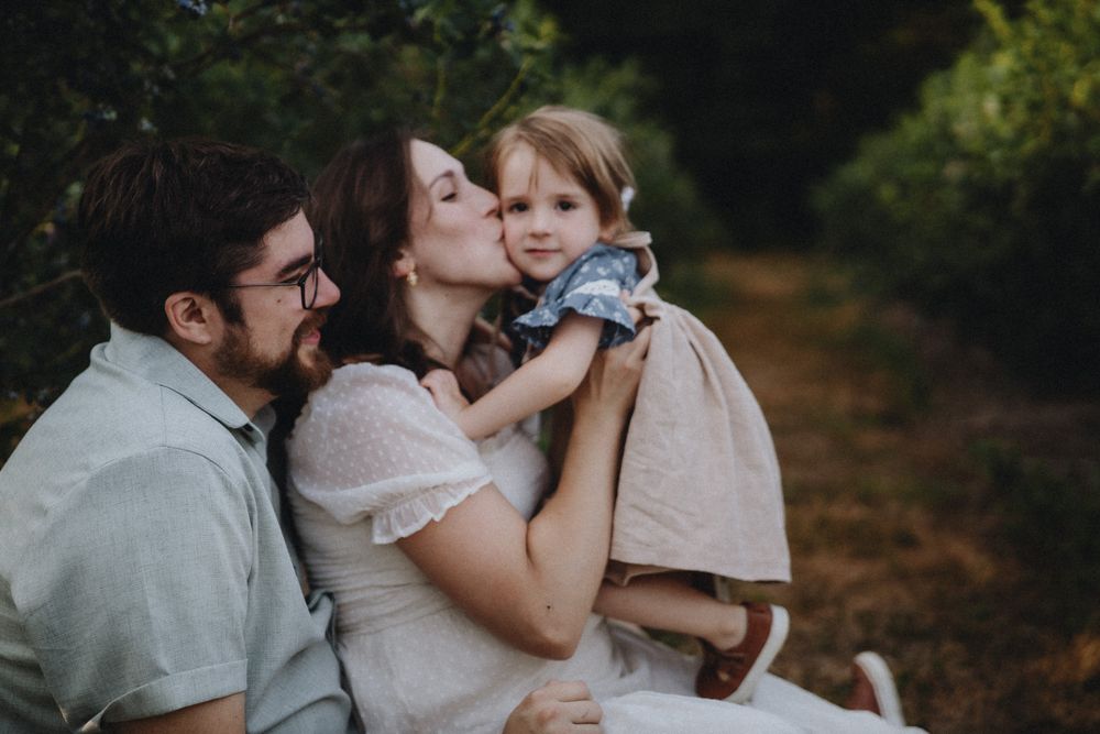 A heartwarming family scene photographed in a natural outdoor setting.