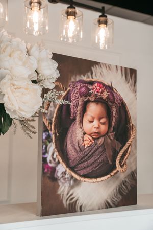 Professional photography display with white floral decor and hanging pendant lights.