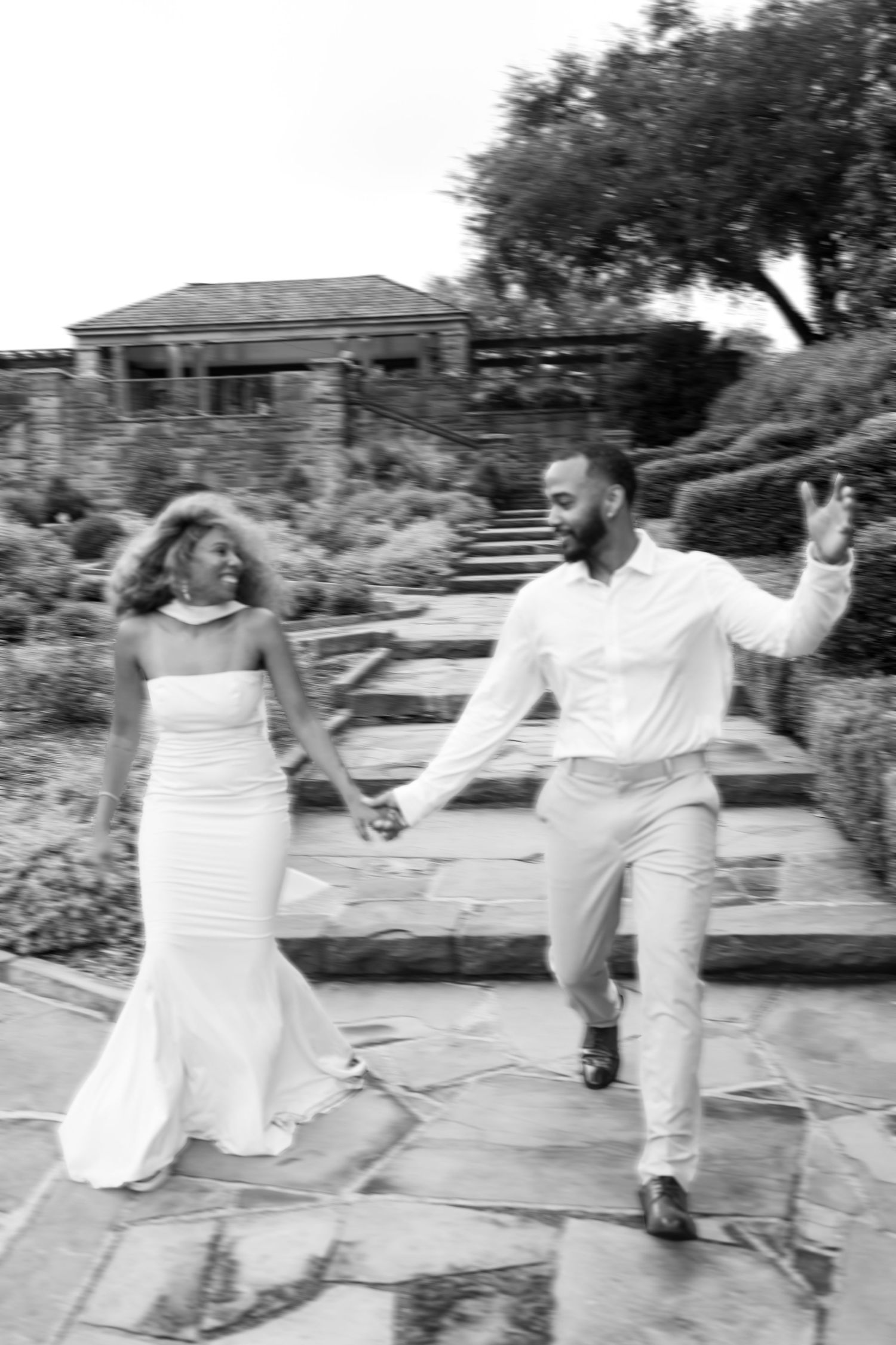 A sequence of black and white photos shows two people dancing together outdoors in flowing white outfits.