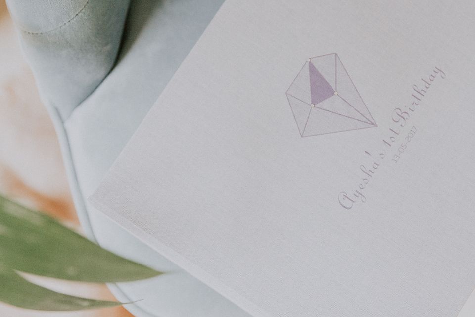 Close-up view of a minimalist geometric logo design in pale purple on white stationery.