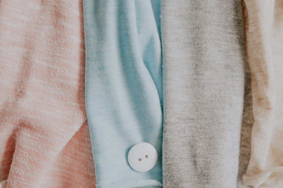 Macro shot of pastel colored fabric textures with a white button detail.