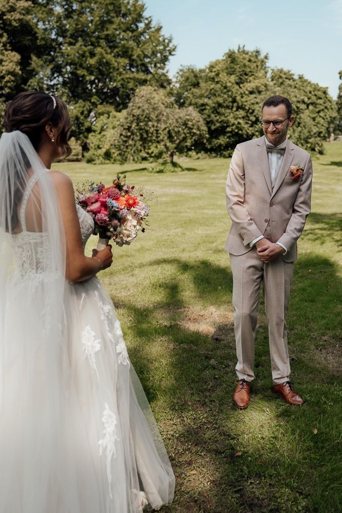 Outdoor wedding first look sequence showing bride and groom meeting in a sunny garden setting.
