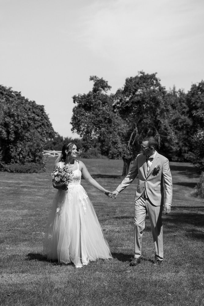 Black and white wedding photography sequence showing a couple's first look in an outdoor garden setting.