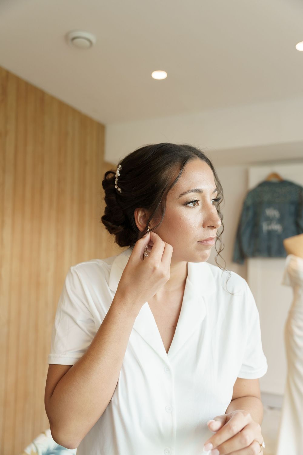Preparation scene with elegant white attire and soft lighting in a dressing room.