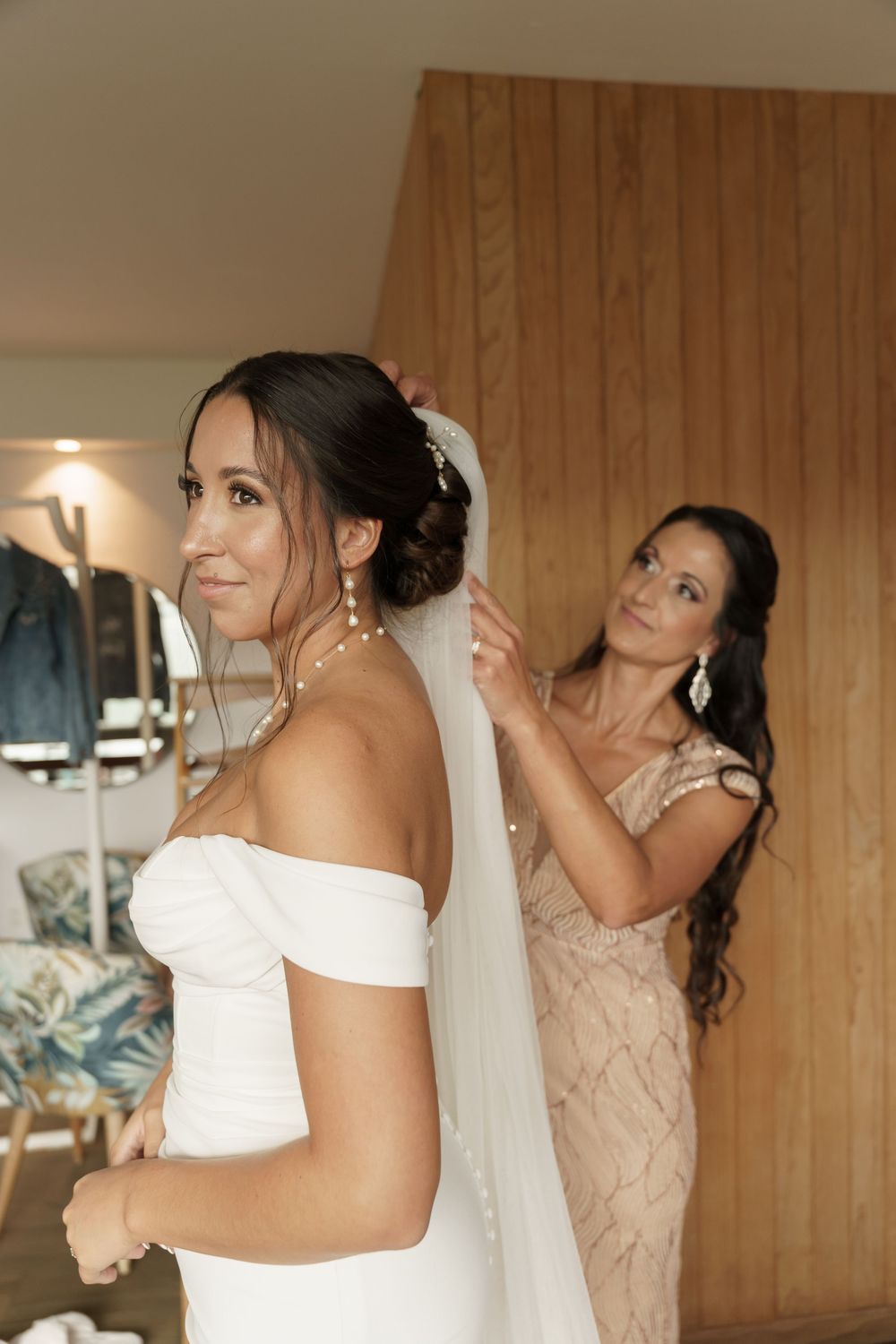 Bridal party getting ready in blush colored dresses with wedding preparations underway.