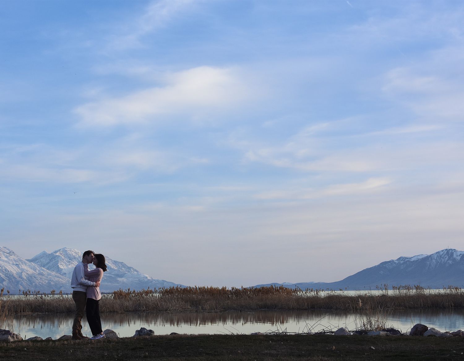 Couple kissing in front of Utah Mountain landscape.