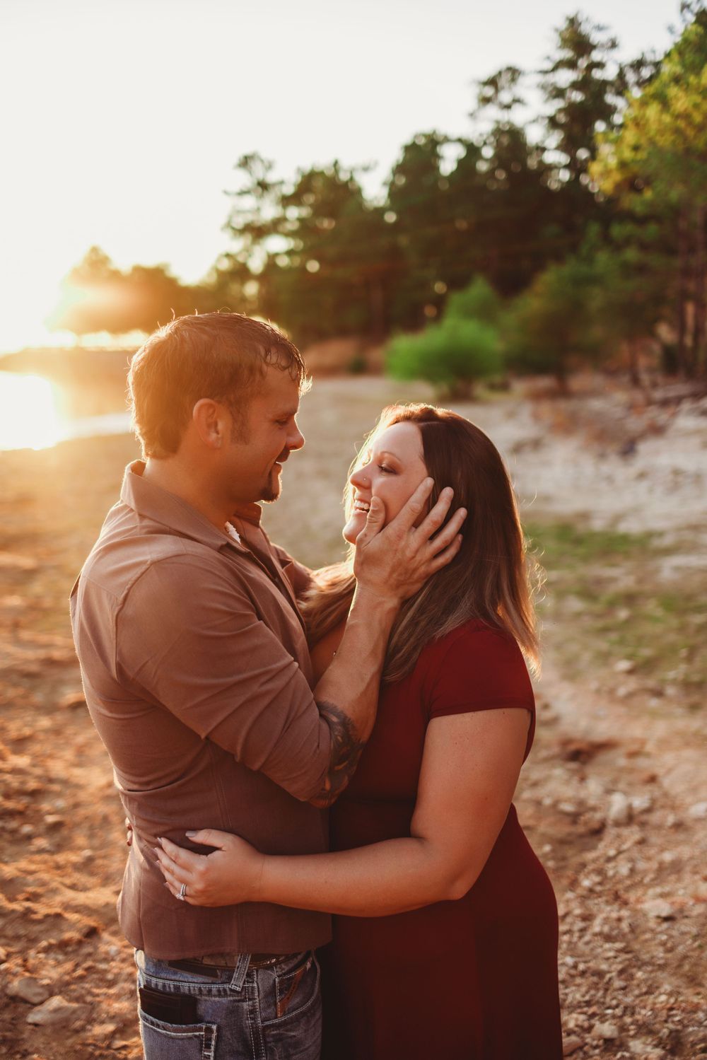 Couple sharing romantic moment on beach during golden hour sunset.