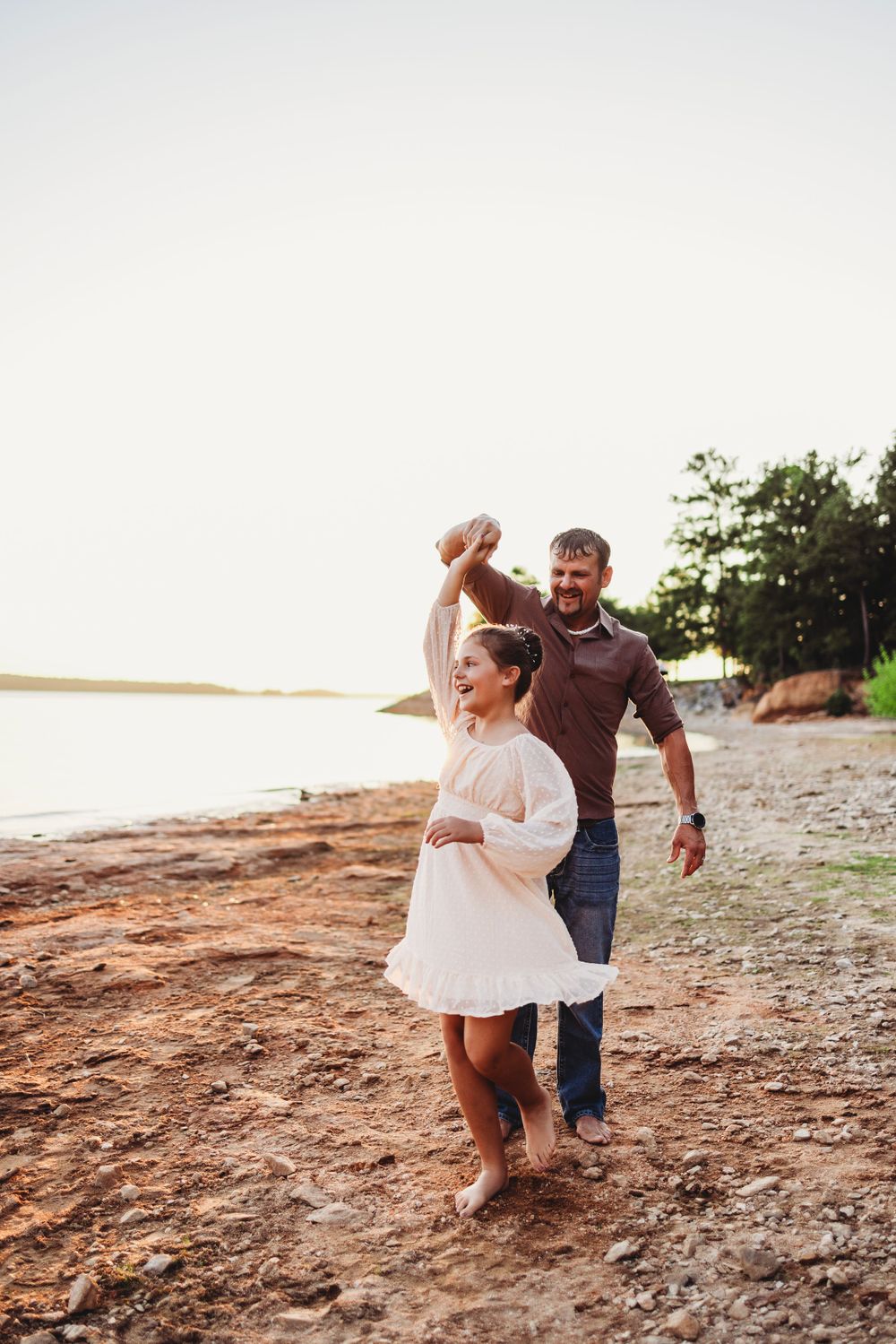 Couple dancing together on beach during golden hour sunset.