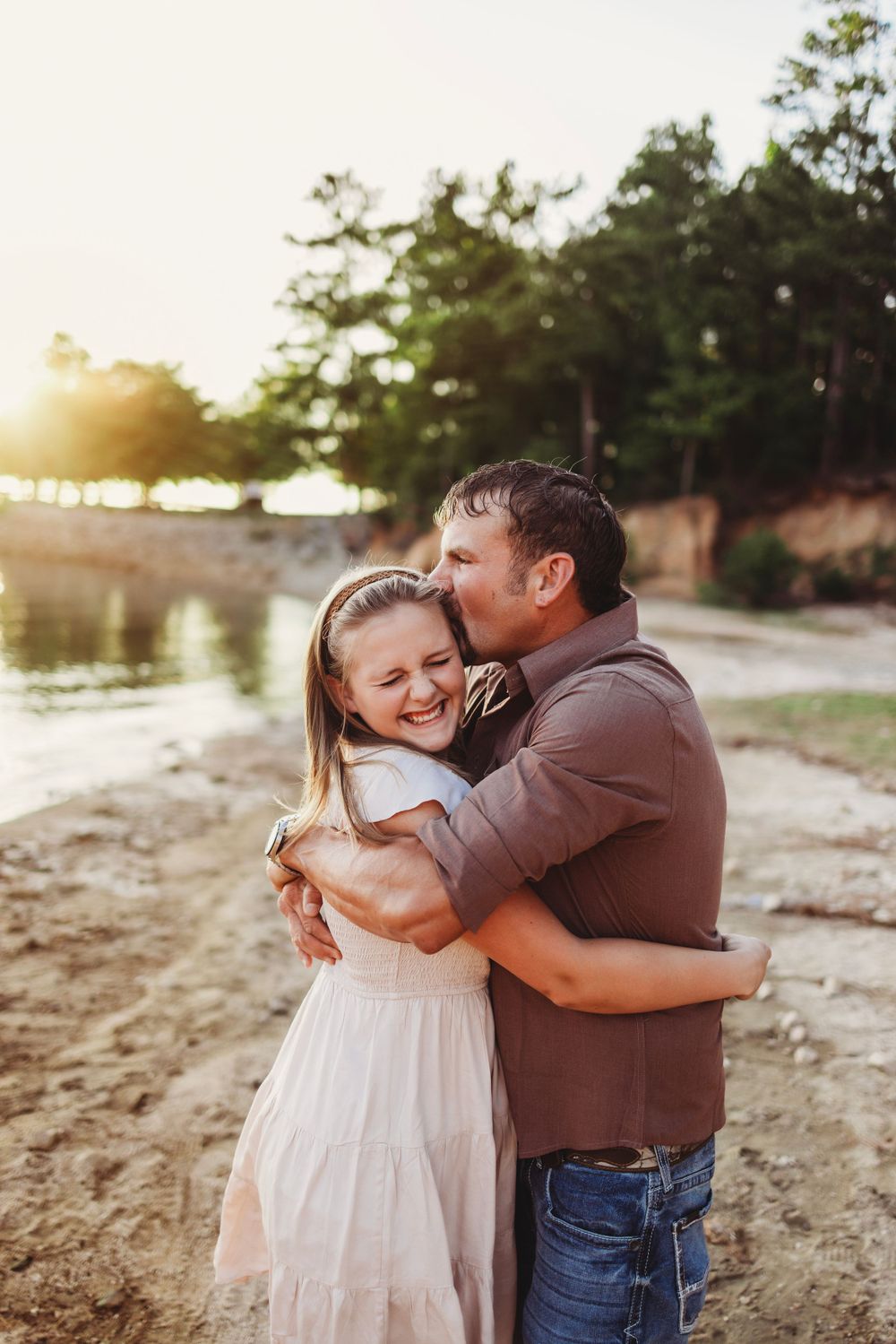 Sweet embrace between two people on a beach during golden hour.