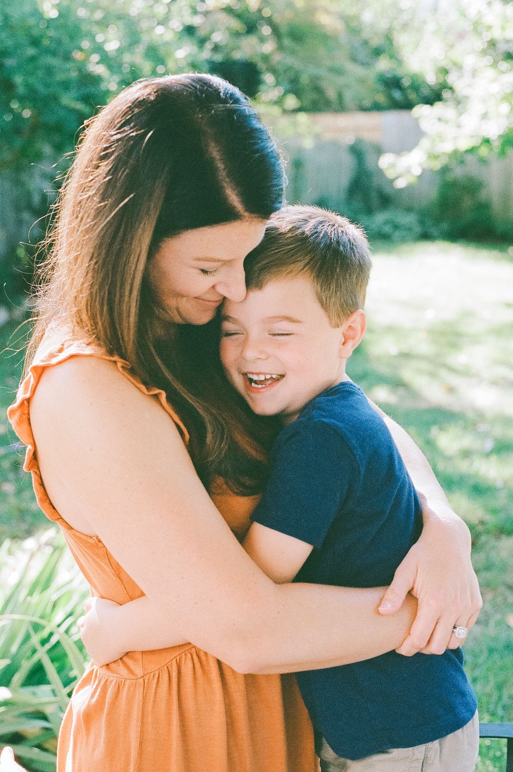 An intimate moment of laughter and hugs shared on a sunny afternoon in the garden.