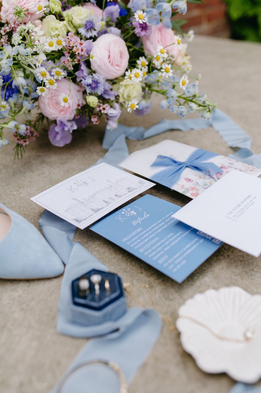 Wedding stationery in powder blue with spring floral arrangements and ring box.