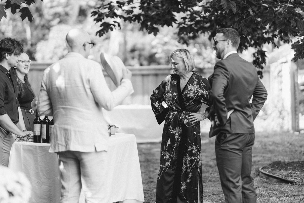 Guests enjoying conversation at an outdoor social gathering with refreshment tables.