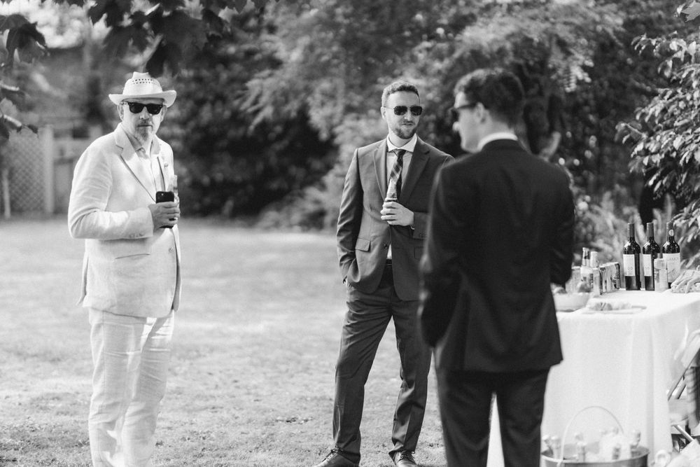 Guests enjoying drinks and conversation at an outdoor garden party.