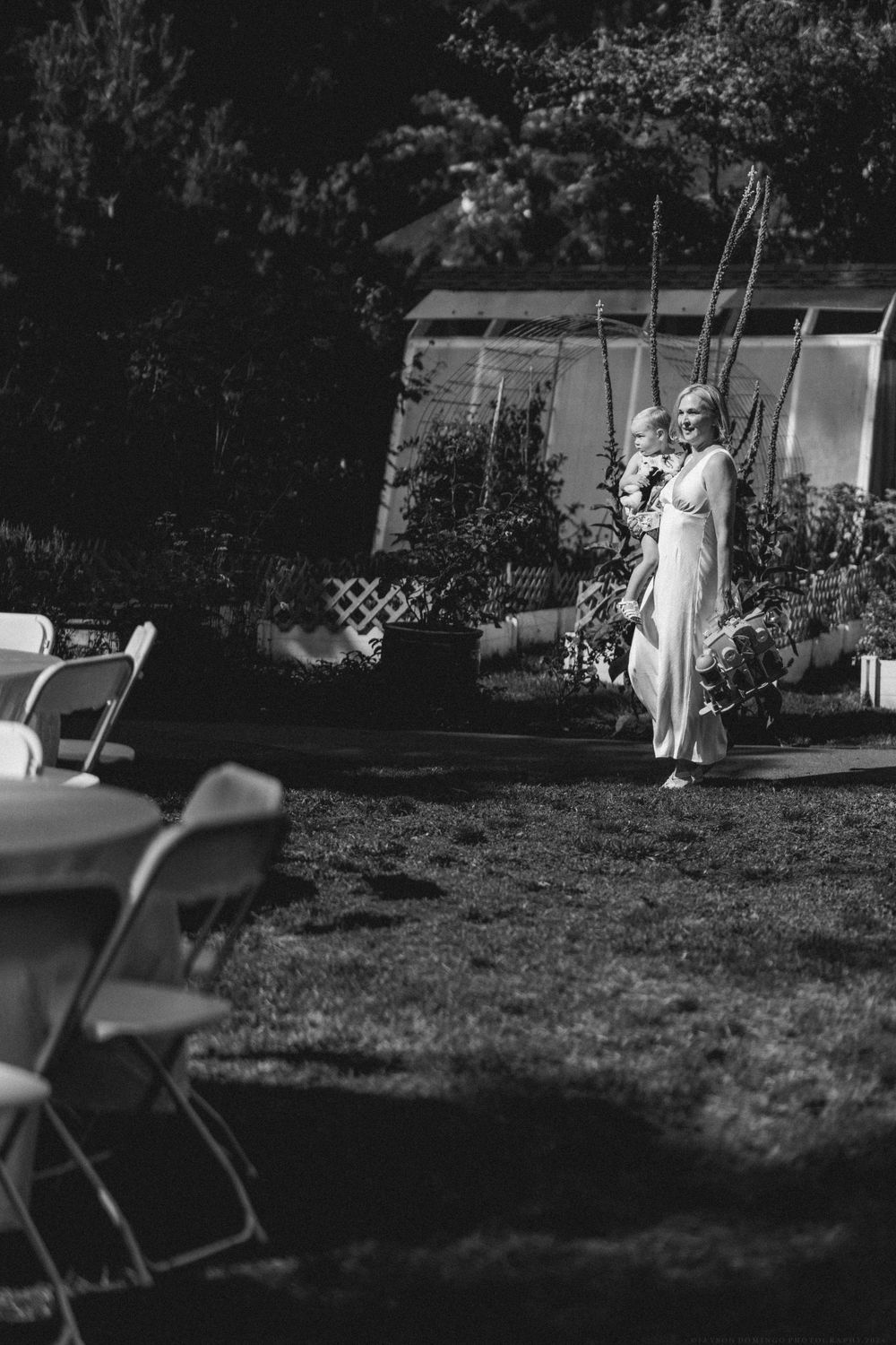 Black and white photo of an elegant outdoor garden party with chairs set up on the lawn.